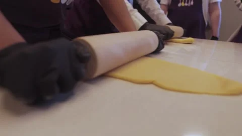 Black gloved hands rolling out pasta dough, pizza dough. Stock Footage 300028346