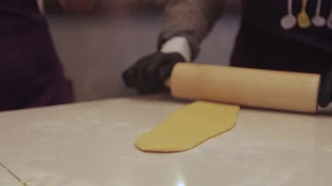 Black gloved hands rolling out pasta dough, pizza dough. Stock Footage 300028347