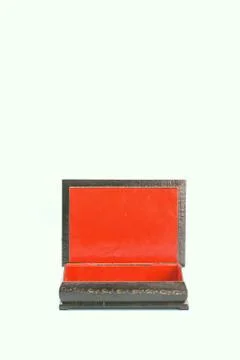 Black with gold painted empty lacquered wooden casket stands open. Inside is red Stock Photos