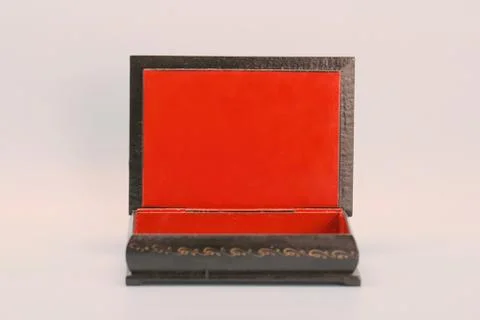 Black with gold painted empty lacquered wooden casket stands open. Inside is red Stock Photos