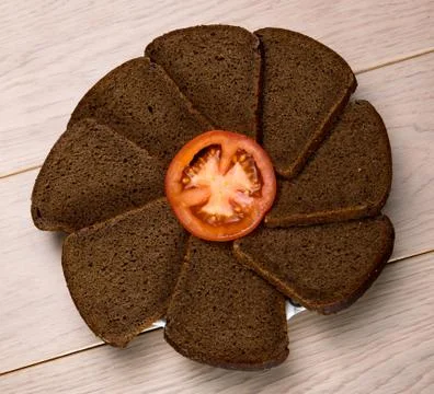 Black grain bread a plate isolated on wooden table background Stock Photos