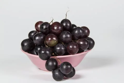Black grape pink bowl Stock Photos