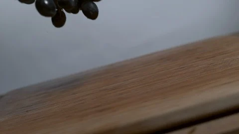 Black grapes being dropped onto a cutting board in slow motion Stock Footage 100008364