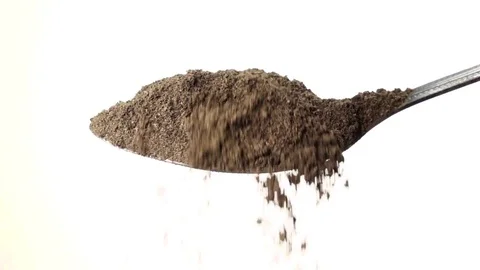 Black ground pepper falling from the iron spoon. White background. Slow motion Stock-Footage 75523952