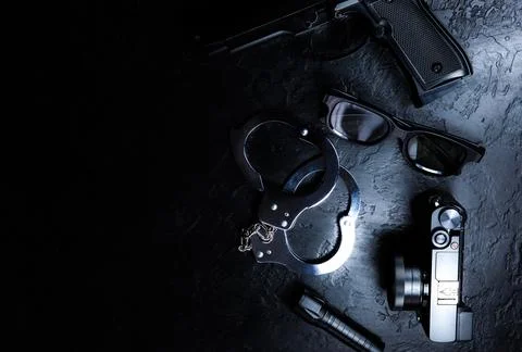 Black gun, flashlight, glasses, camera and Police metal real handcuffs lie .. Stock Photos
