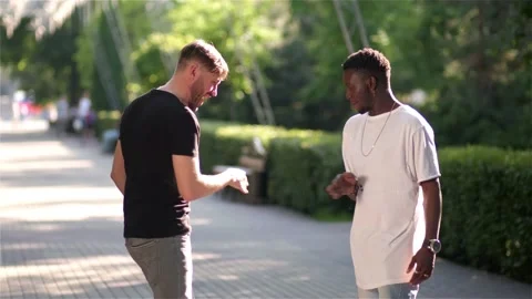 Black guy and white guy greet each other and dance in the street Stock Footage 132366083