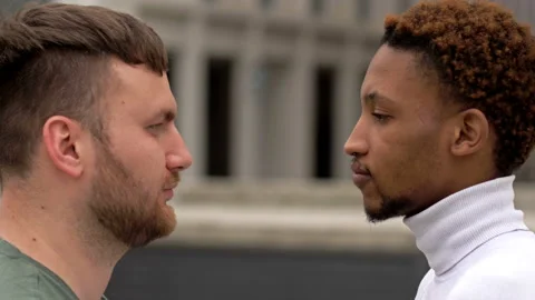 The black guy and the white man are staring at each other. Concept of Stock Footage 132488342