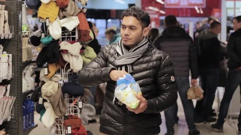 Black guy from Dubai in a supermarket eats corn sticks and is happy Vídeos de archivo 82906702