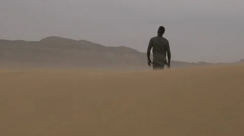 Black guy falls on bended knee at the middle of the dessert of morocco Video stock 67558554