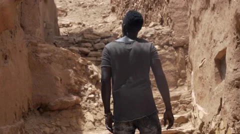 Black guy  going up the stairs of sand at Morocco Stock Footage 67557883