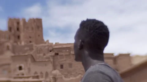 Black guy looking around at the sand houses 14 Stock Footage 67528974