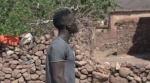 Black guy looking around at the sand houses 02 Video stock 67557052