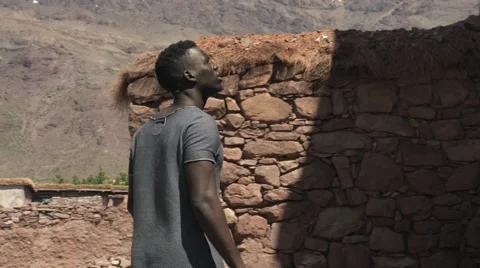Black guy looking around at the sand houses 04 Video stock 67557072