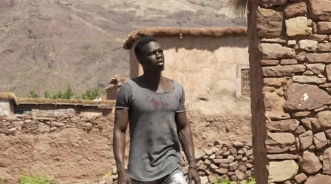 Black guy looking around at the sand houses 05 Stock Footage 67557200
