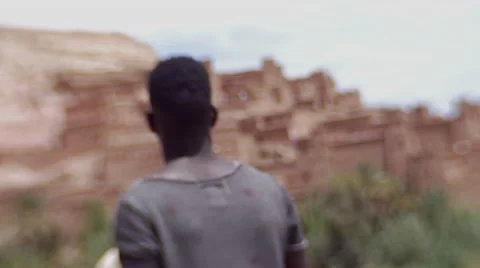 Black guy looking around at the structures of sand at morocco 06 Video stock 67527559