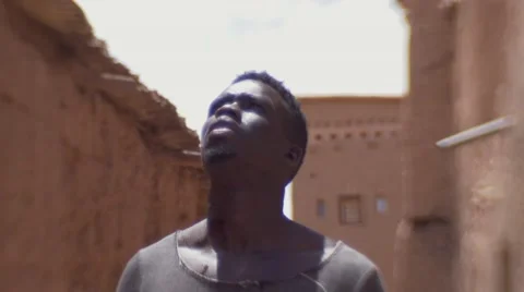 Black guy looking around at the structures of sand at morocco 05 Video stock 67528936