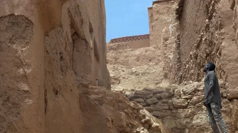 Black guy looking around at the structures made of sand at morocco Stock Footage 67557893