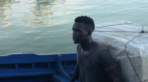 Black guy looks around while riding a boat 05 Stock Footage 67532439