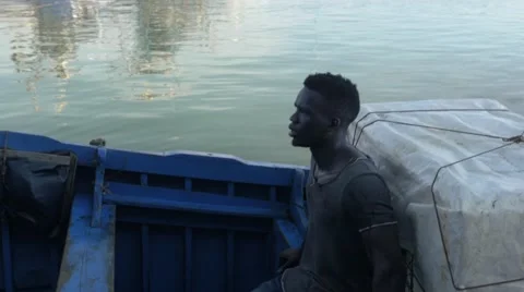 Black guy looks around while riding a boat 03 Stock Footage 67532441