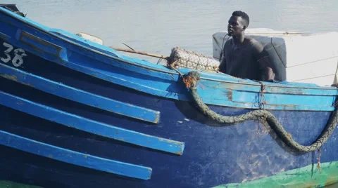 Black guy looks around while riding a boat Stock Footage 67532804