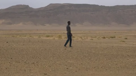 Black guy at the middle desert of Morroco Stock Footage 67558678