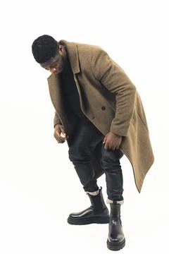 Black guy modeling looking at his shoes white background - full shot Stock Photos