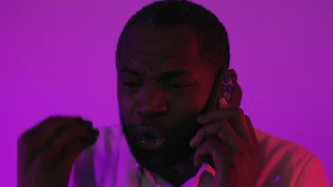 Black Guy Sitting and Talk by Smartphone. African American Man Quarrel by Phone Stock Footage 231439949