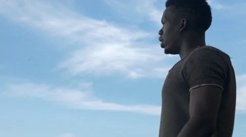 Black guy thinking at a windy cloudy area Stock Footage 67556451