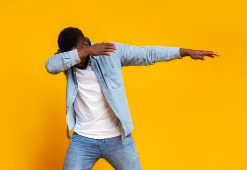 Black guy throwing dab move over yellow background in studio Stock Photos