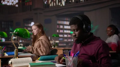 Black guy using study music to help with deep focus for academic success Stock Footage 308719916