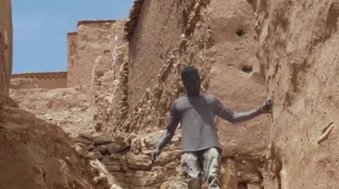 Black guy walking down the stairs of sand at morocco Stock Footage 67557865