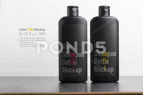 Black hair shampoo bottles in front of  light gray background mock-up series Modello PSD