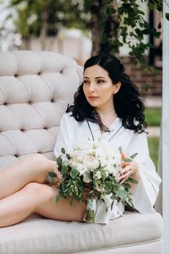 Black-haired bride prepares for her wedding in a boudoir Stock Photos