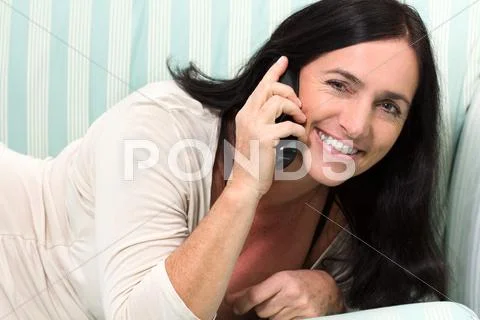 Black haired woman talking on phone Stock Photos