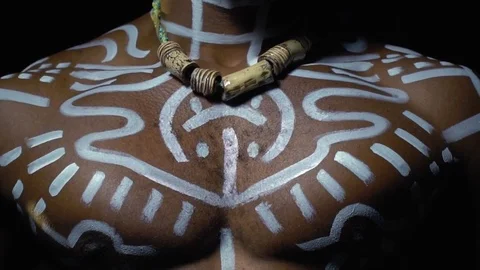 Black hairy man in white patterns with a necklace on his neck, slow motion Stock Footage 82121191