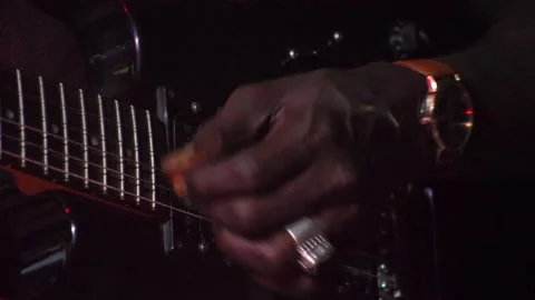 Black hand with ring playing with plectrum on black electric guitar up side down Stock-Footage 208939946