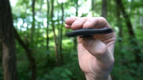 Black hand spinner, or fidgeting spinner, rotating on child's hand.grass Stock Footage 77151875