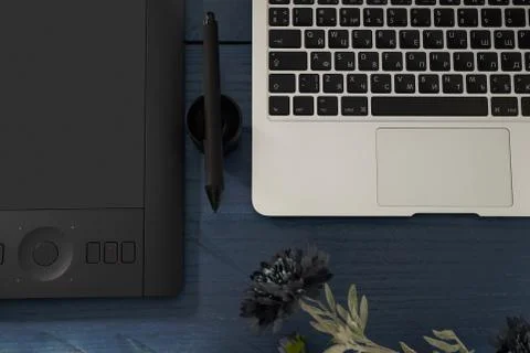 Black handle professional graphics tablet, notebook and flower top view Photos