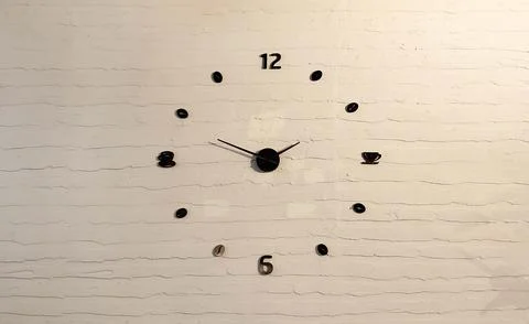 The black hands and numbers of the dial are on the background of a white bric Stock Photos