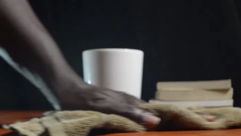 Black hands cleaning a desk table slowly with a rag Stock Footage 276594096