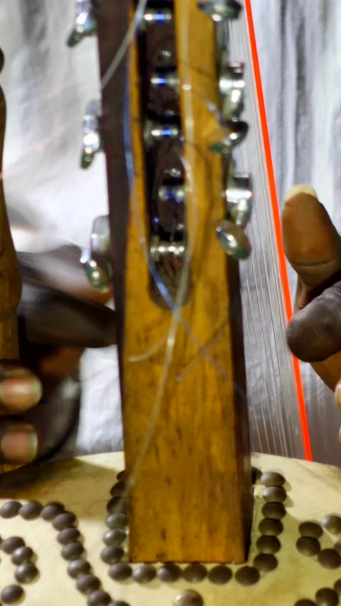 Black hands plucking the strings of kora instrument from front Stock Footage 230691977