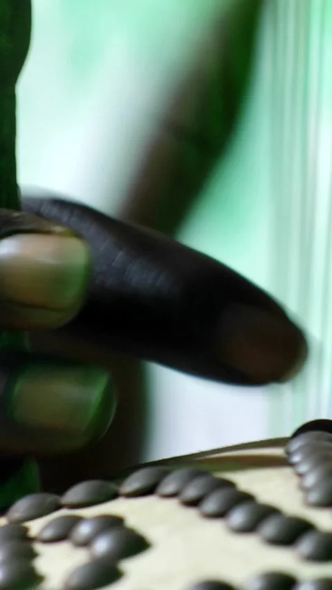 Black hands plucking the strings of kora instrument from front Video stock 230692093