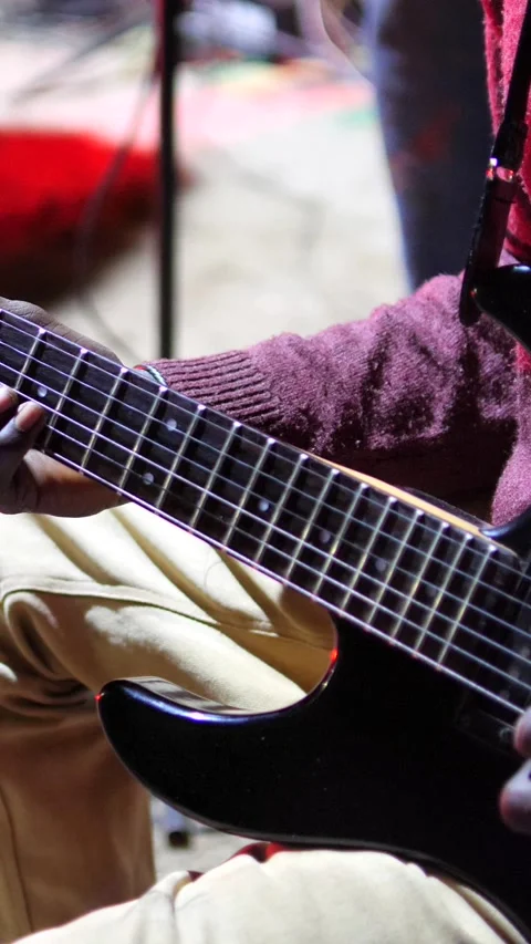 Black hands with ring playing with plectrum on electric guitar up side down Stock Footage 230686219