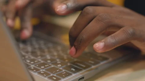 Black hands typing laptop keyboard, focused developer editing code, warm desk Stock Footage 333182632