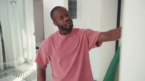 Black handsome guy getting dressed for work in front of mirror. Young african Stock Footage 131670548