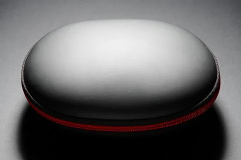 Black hard bag in a shell form with red zipper on dark background Stock Photos