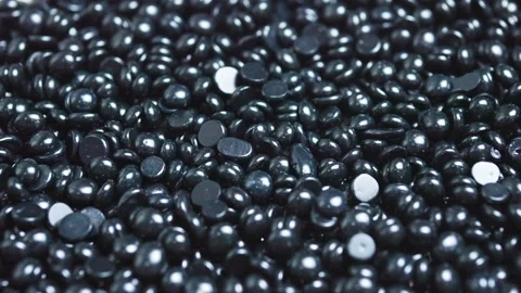Black hard wax beans featuring glossy surface, forming textured pattern Stock Footage 311117418