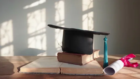 Black hat blue tassel graduates placed on the wooden table Stock Footage 148101331