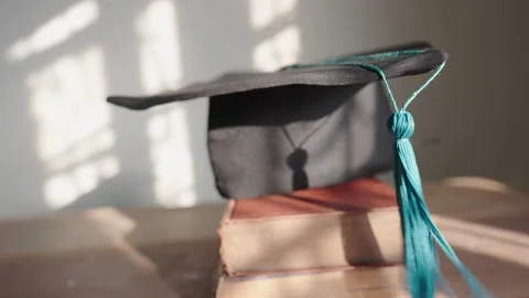 Black hat blue tassel graduates placed on the wooden table 動画素材 148101351