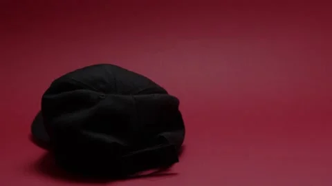 Black hat that falls on a red background Stock Footage 198371972